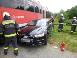 autó beszorult a vonat és a korlát közé