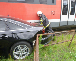 tűzoltó szemléli a beszorult autót