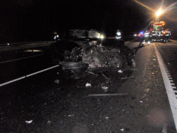 összetört autó áll az út közepén