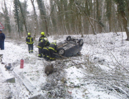 tűzoltók áramtalanítanak, az autó össze van törve az árokba borult
