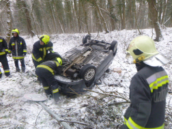 tűzoltók áramtalanítanak, az autó össze van törve az árokba borult