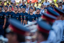 Az esküt tett tűzoltók vigyázzban állnak az alakzatban, háttérben a családtagok.