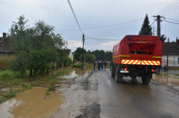 kötél egyesület teherautója áll az úton, háttérben az elöntött falu