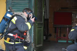 légzőkészüléket veszi fel a tűzoltó